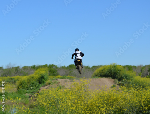 Motocross Rear Jump/Rear view of motocross rider jumping a small hill