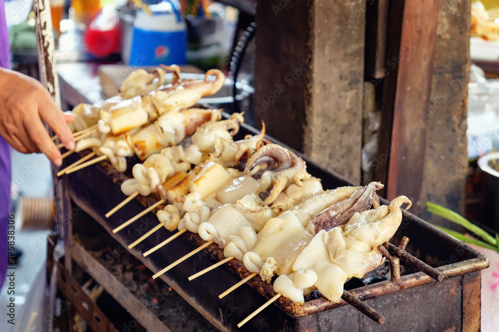 Φωτογραφία Fresh Squid on skewers is being grilled by a street vendor in the most famous fl