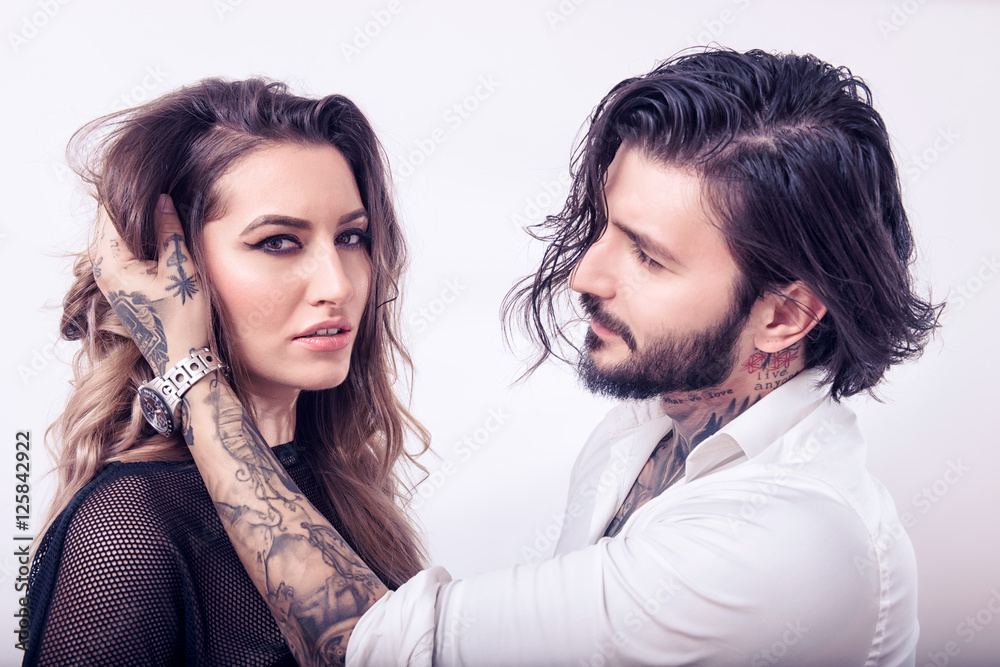 Young man touching a sensual woman's hair on white background