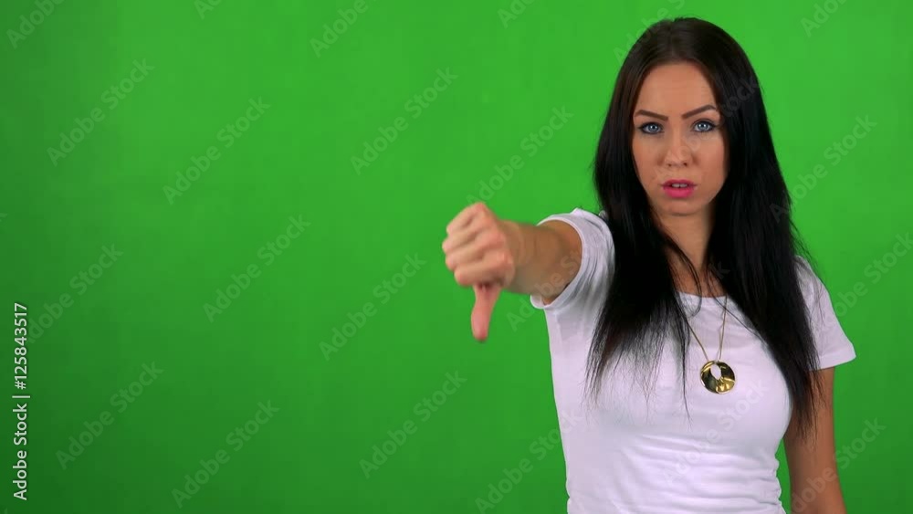 young pretty woman disagrees (show thumb down) - green screen - studio young pretty woman disagrees (show thumb down) - green screen - studio