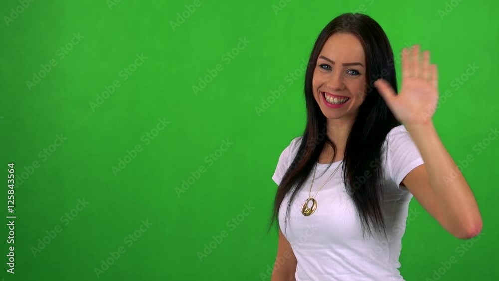 young pretty woman waves with hand - green screen - studio young pretty woman waves with hand - green screen - studio