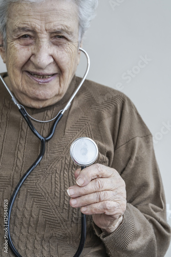 Senior woman holding a stethoscope photo