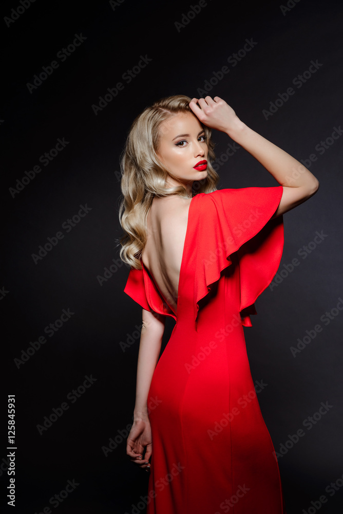 Beautiful blonde girl in red evening dress over grey background. Beautiful blonde girl in red evening dress over grey background.