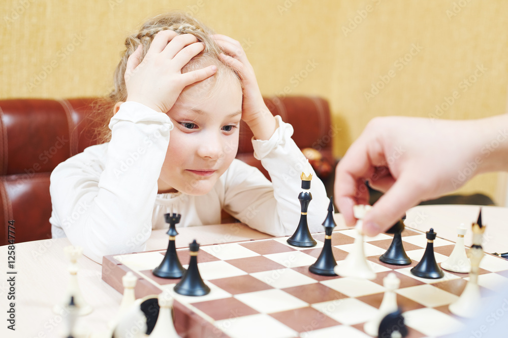 Child girl playing chess game Child girl playing chess game