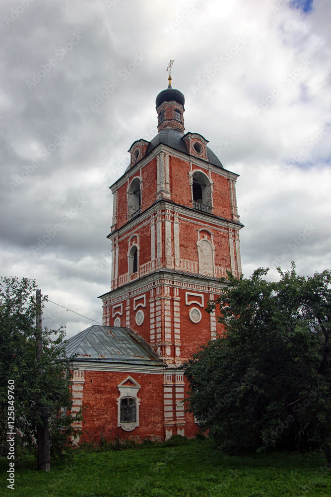 the old russian Orthodox bell tower of red brick with red walls