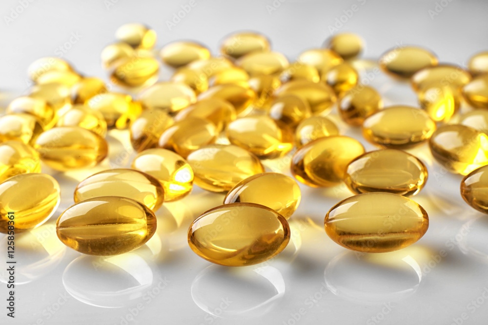 Capsules of fish oil on light background, close up view Capsules of fish oil on light background, close up view