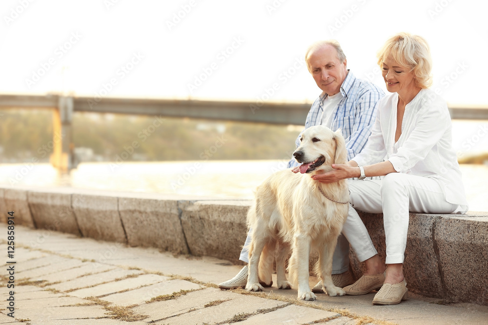 Senior couple and big dog on bund Senior couple and big dog on bund