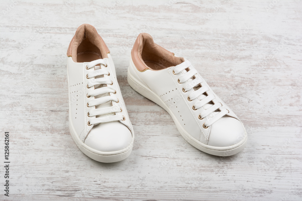 Women's sport shoes on white wooden background