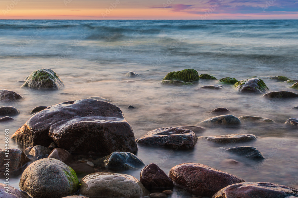 Sunset over the sea. Stone on the foreground. Sunset over the sea. Stone on the foreground.