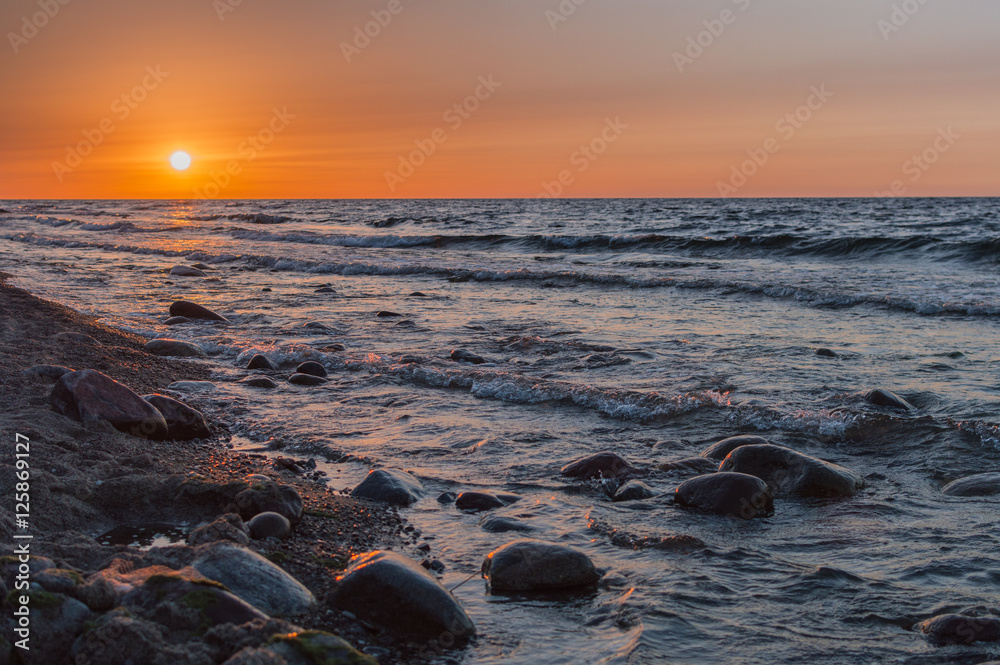 Obraz premium Sunset over the sea. Stone on the foreground.
