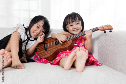 Asian Chinese little sister playing ukele photo