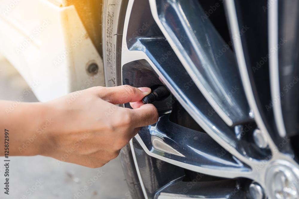 Man checking air pressure and filling air in the tires of car. Concept picture Man checking air pressure and filling air in the tires of car. Concept picture