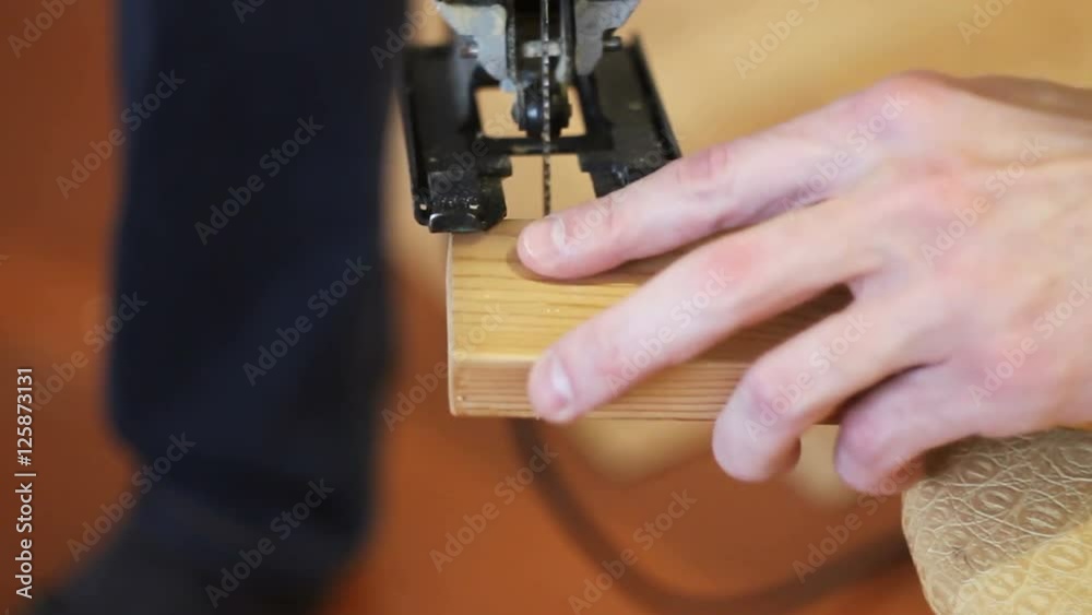 the young man adjusts electric jigsaw the young man adjusts electric jigsaw
