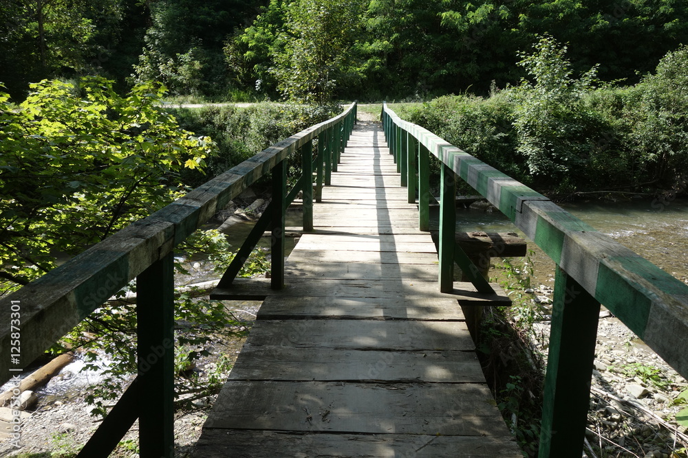 Wooden bridge over mountain river. Transcarpathia