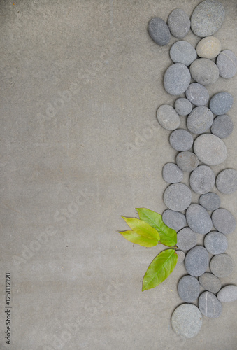 Set of bamboo leaves on pile of gray stones-gray background