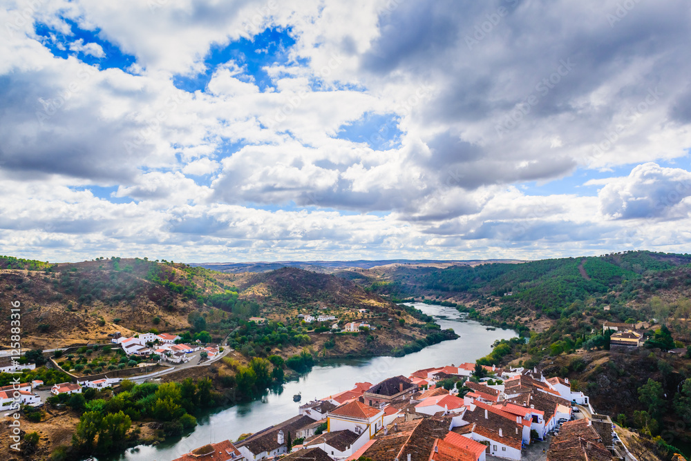 The sky over the river Guadiana and the village of Mertola. Alentejo Region. Portugal