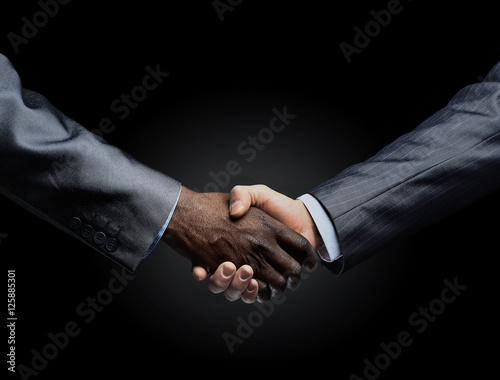 African businessman's hand shaking white businessman's hand