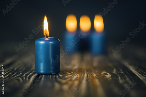 Lit four blue candles on wooden counter
