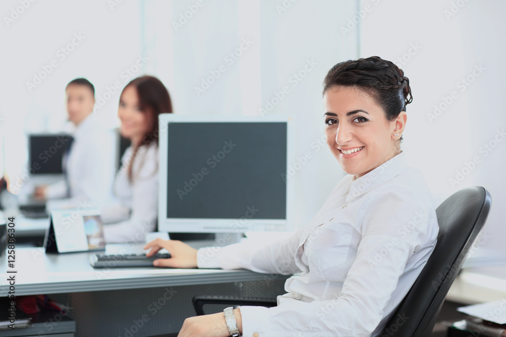 Closeup portrait of business woman giving you cute smile with colleagues in background Closeup portrait of business woman giving you cute smile with colleagues in background