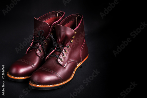 High boots. Fashionable mens leather brown shoes on black background. Back view. Copy space. © bondarillia