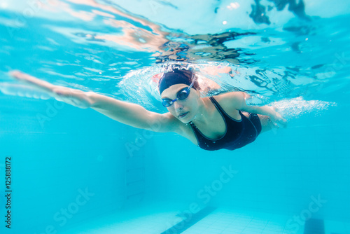 Female swimmer gushing through water in pool