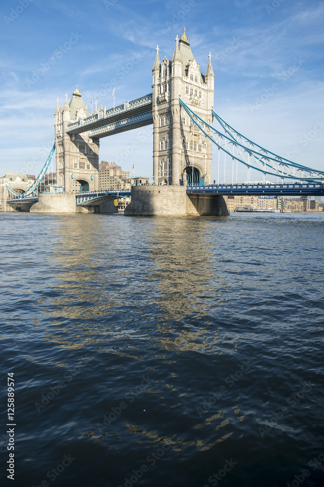 Scenic landscape view of Tower Bridge standing tall in afternoon light above the River Thames as viewed from the South Bank in London, England