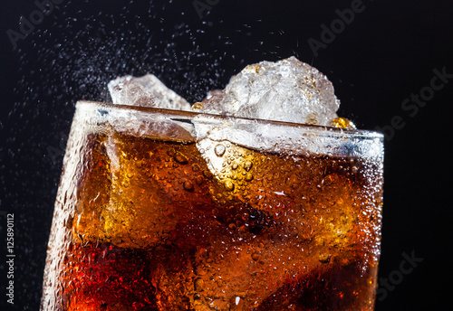 Cola drink fizz with ice in a glass