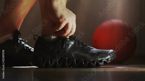 The athlete wears sneakers and tying shoelaces