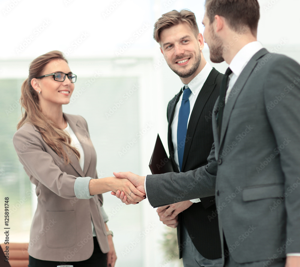Business partners shaking hands in the modern office Business partners shaking hands in the modern office