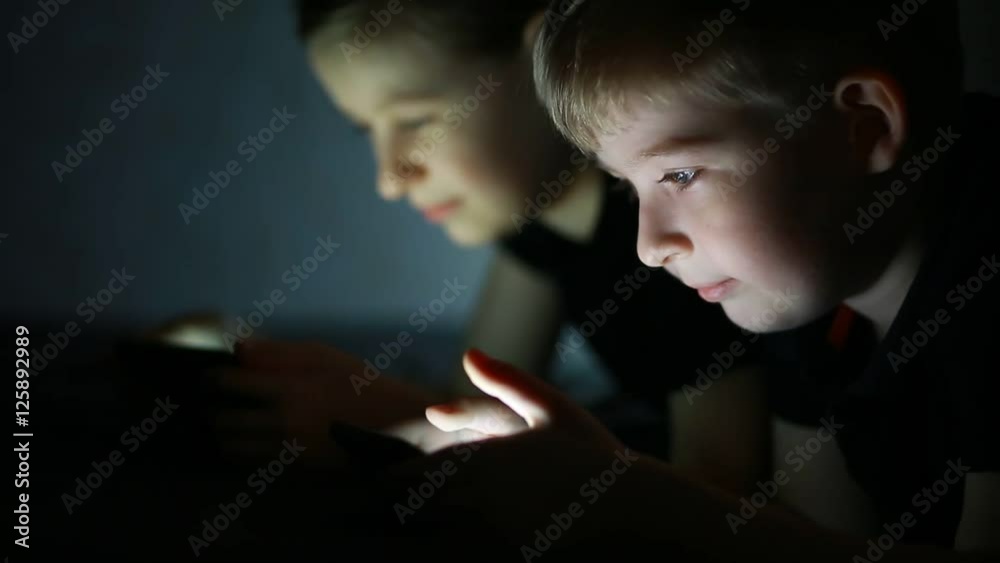 Boy and girl looking at smart phones Boy and girl looking at smart phones