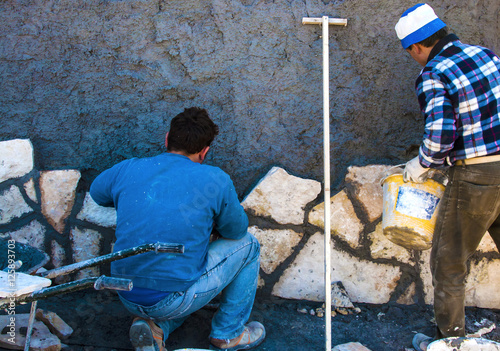 Construction site - workers wall cladding stone