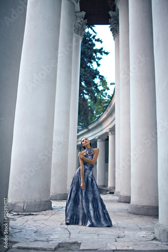Bild auf Leinwand young lady in dress at the entrance of neoclassical building