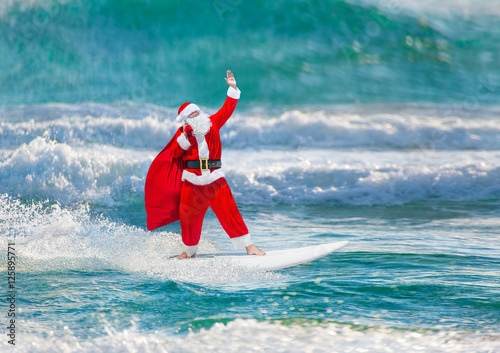 Santa Claus windsurfer with gifts sack surfing at ocean waves