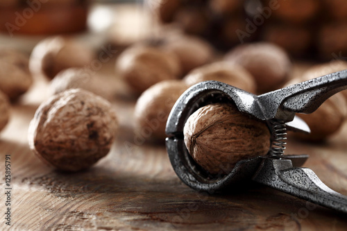 walnut in a nutcracker on a wood background