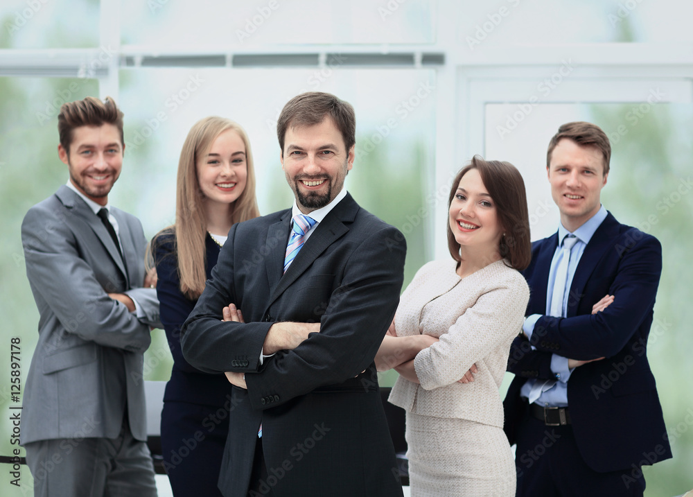 Smiling business team standing upright with their hands on their Smiling business team standing upright with their hands on their