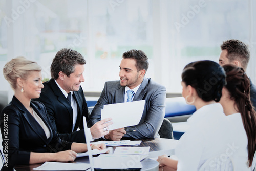 Image of business partners discussing documents and ideas at meeting