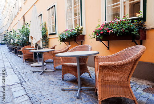 Street view of a coffee terrace with tables and chairs in europe