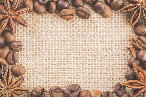 Frame with coffee beans on sackcloth with spices anise