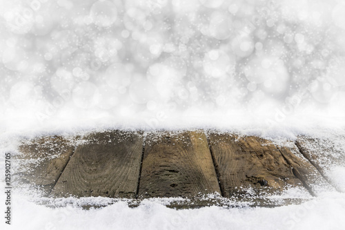 Alte Holzbretter im Schnee mit Bokehhintergrund photo