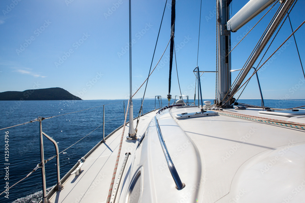 The white sails of yachts on the background sea and sky in the clouds The white sails of yachts on the background sea and sky in the clouds