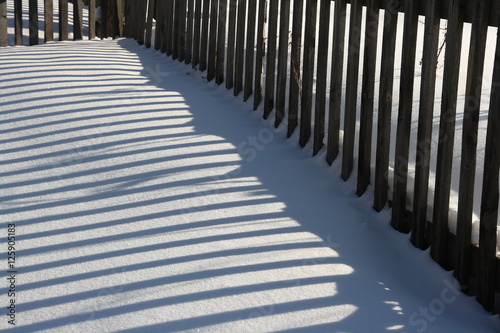 fence shadow on snow accumulated deck