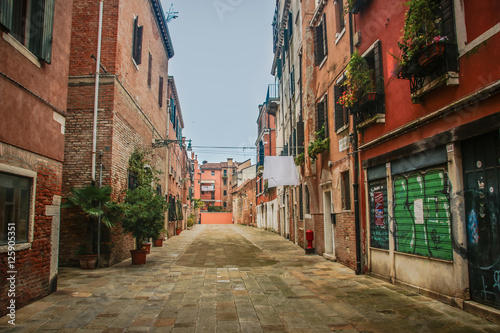Street in Venice, decorated with flowers, in Italy