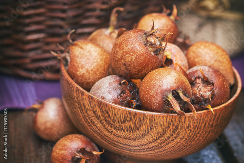Common medlar fruit (mispel) in wooden bowl
