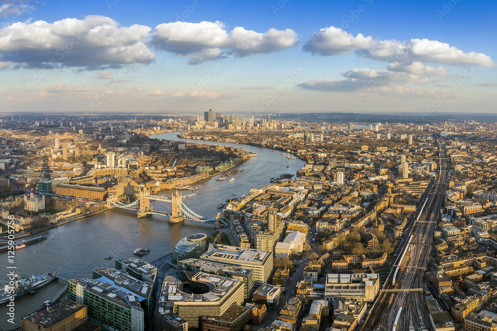 London, England - Panoramic aerial view of London with the famous Tower and Tower Bridge and skyscrapers of Canary Wharf at the background