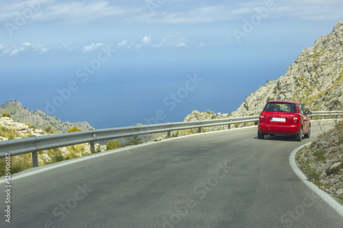 Red car on highway in mountains