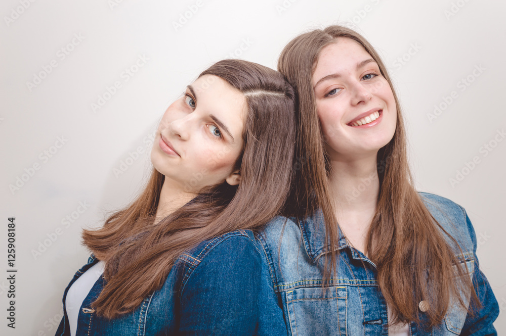 fashion photo of two beautiful young women with long dark hair and bright makeup wears casual clothes,posing in studio fashion photo of two beautiful young women with long dark hair and bright makeup wears casual clothes,posing in studio
