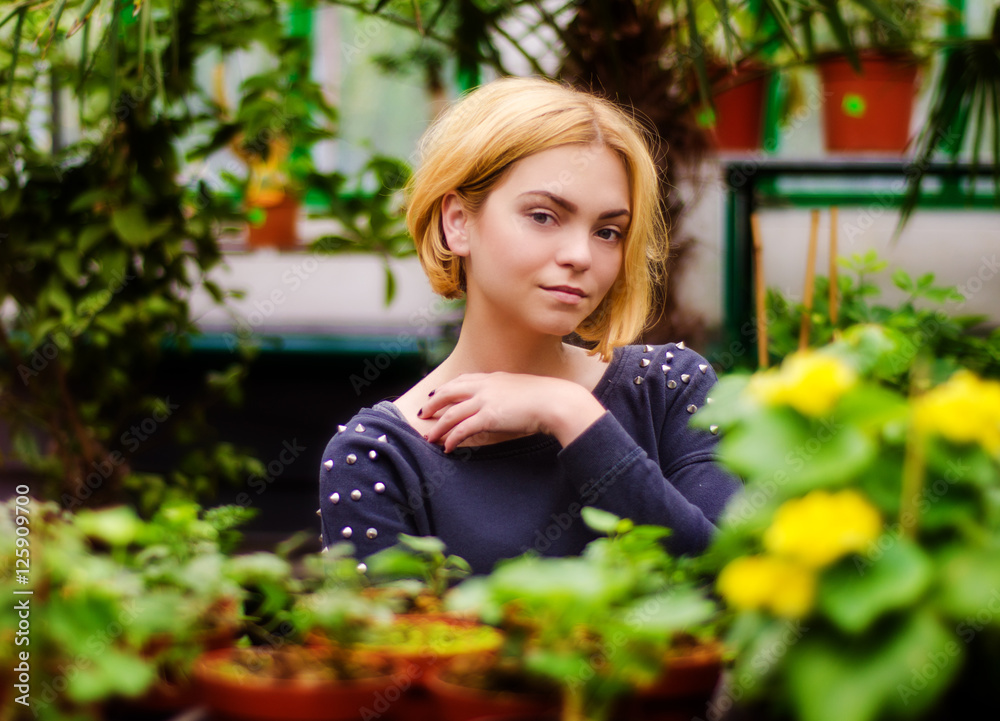 portrait of a young blonde with flowers in the greenhouse portrait of a young blonde with flowers in the greenhouse