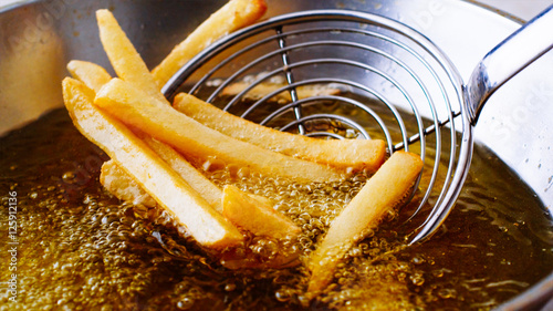 Fényképezés French fries in a deep fryer
