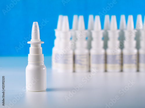 nasal spray bottle in front of other bottles row, shallow depth of field, advertisement concept