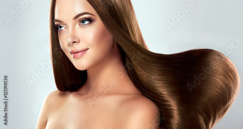 eautiful model girl with shiny brown straight long hair . Care and hair products . 